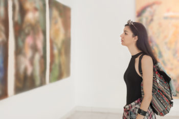 a woman looking at art in a museum
