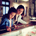 adult and child looking at an exhibit in a case in a museum | littleton museum lone tree