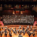 a full orchestra performing on stage in a concert hall | symphony Lone Tree