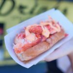 lobster roll on a plate in a woman's hand | lobster rolls Lone Tree