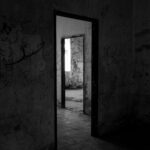 black and white image of a door frame in a spooky looking house | haunted houses Lone Tree