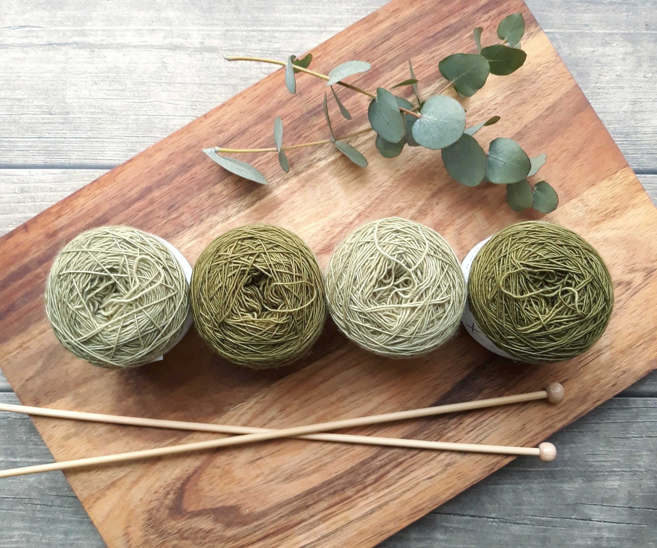 four balls of yarn and hooks on a wooden table | knitting Lone Tree
